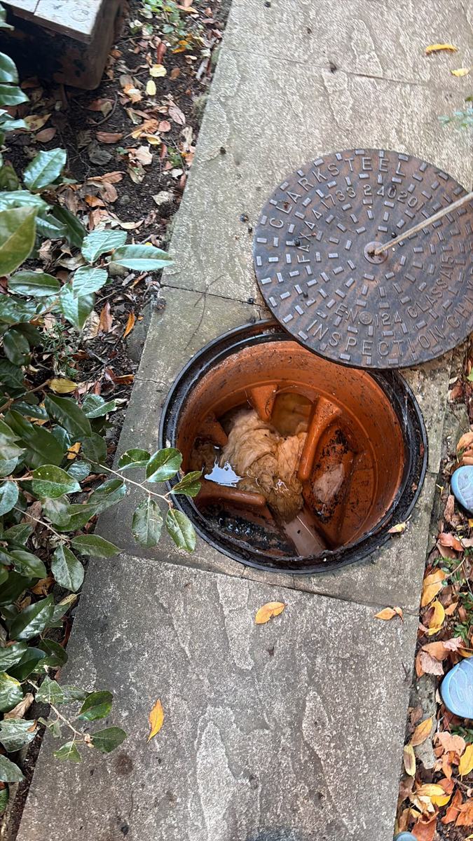 Open drain inspection chamber with cast iron cover lifted